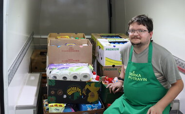 Dobrovolník u předání 15ti beden pomoci.